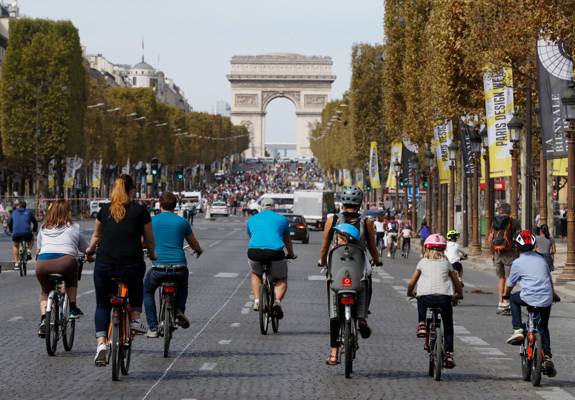 Fahrradfahrer auf Straße mit Blick auf Arc de Triomphe, Paris, Frankreich