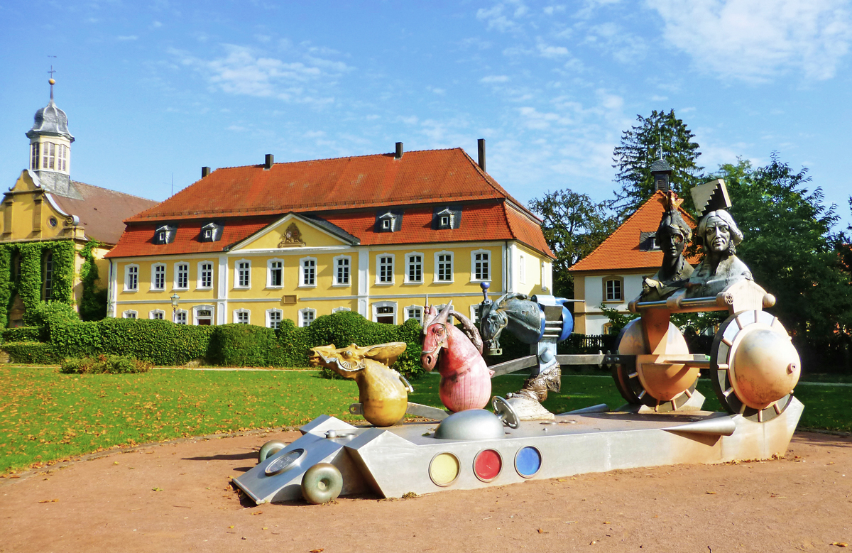Im Vordergrund die Großplastik Chariot 1889 (Wagenlenker), im Hintergrund links die ehemalige Schlosskapelle, heute das Atelier von Jürgen Goertz, und daneben das Rentamt in Eichtersheim.